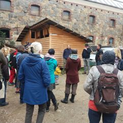 Ein regionaler Bio-Landbauer steht vor einer Gruppe und erklärt