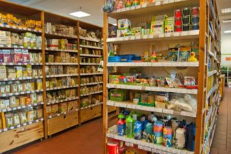 Innenansicht der Biomarktes am Pohlandplatz, ein Holzregal mit Spielsachen und Emil-Trinkflaschen für Kinder