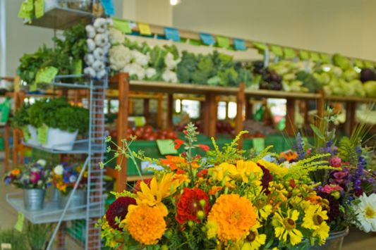 Blumenstrauß vor der Gemüseabteilung im Bioladen