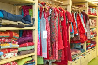 Ladeneinrichtung aus Holz mit einer Auswahl an bunten Öko-Textilien