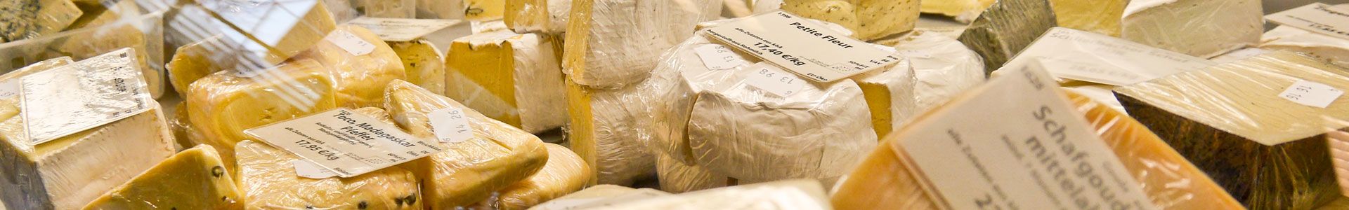 Nahaufnahme geschnittener Käsesorten in einer Auslage