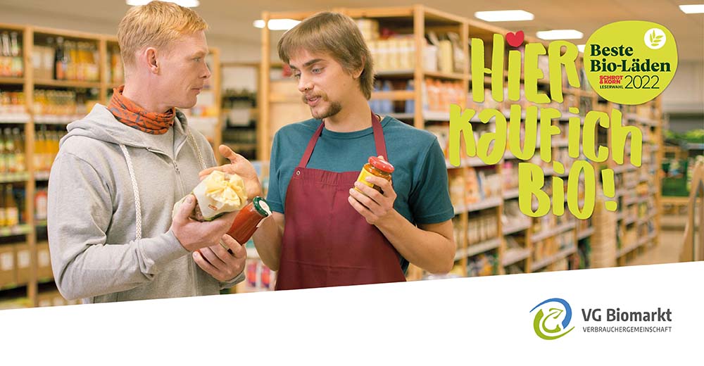 Verkäufer und Kunde im Bioladen mit Slogan Hier kauf ich bio!