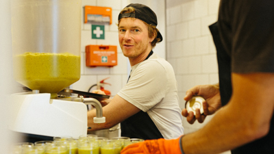 Mann befüllt Gläser mit Brotaufstrich