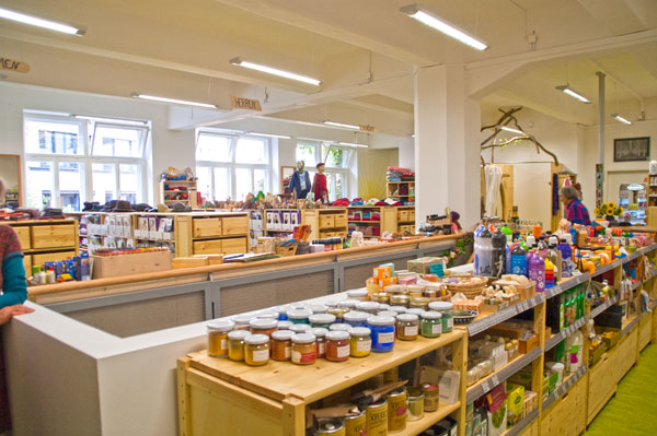 Sortiment von Naturfarben auf einem Holzregal im Naturwarenladen der VG Verbrauchergemeinschaft eG